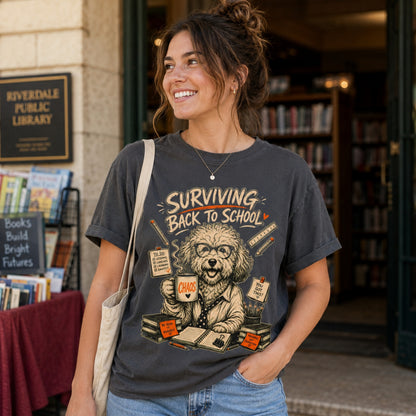 Woman wearing a graphite Surviving Back to School dog teacher T-shirt outside a library.